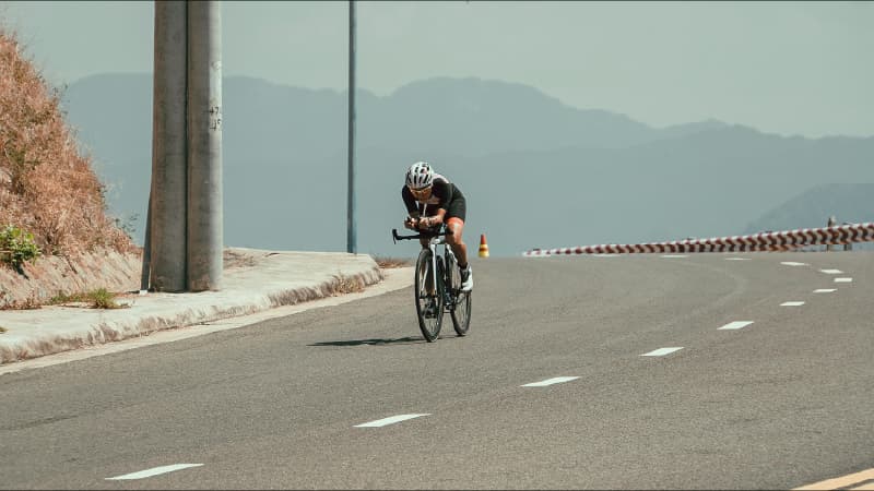 Triathlete riding a time-trial bike on an open desert road